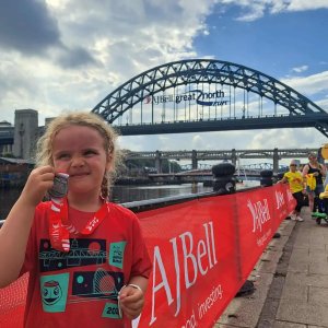 Lucy poses with her mini great north run medal which she counted towards her Agility badge.